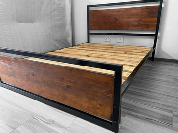 Modern wooden bed frame with black metal accents in a minimalist room.
