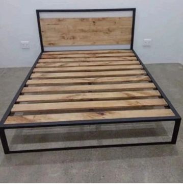 Minimalist bed frame with wooden slats and metal frame.