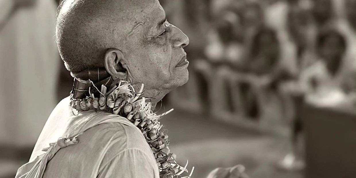 Profile of an elderly man in a peaceful, meditative state with a floral garland.