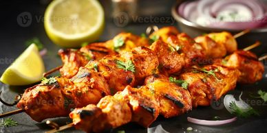 Grilled chicken skewers garnished with herbs and lemon wedges.