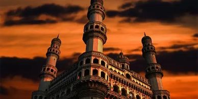 Charminar monument under a dramatic sunset sky.