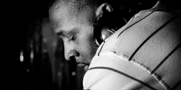 Man in deep focus wearing headphones, captured in black and white.