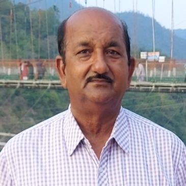Middle-aged man with a mustache in checkered shirt outdoors.