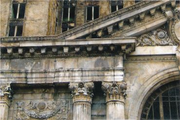 Weathered classical building facade with columns.