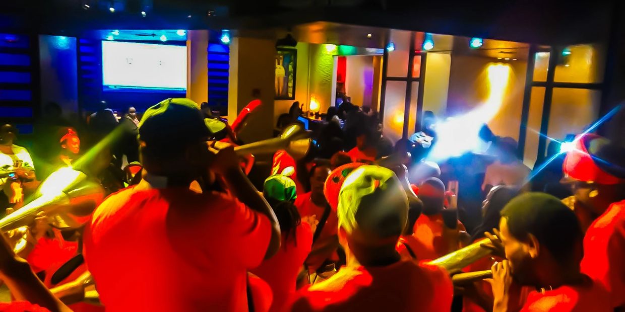 Haitian band with musicians performing live with instruments at a club full with people 