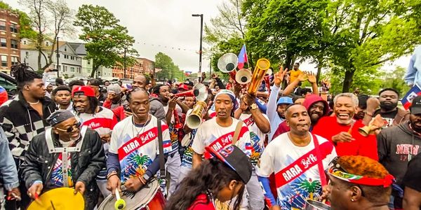 Band performing live in the street followed by hundreds of people 