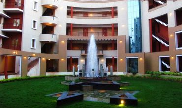 Modern courtyard with a central fountain and surrounding balconies.