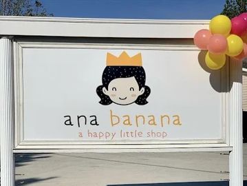 Signboard of Ana Banana, a happy little shop, decorated with colorful balloons.