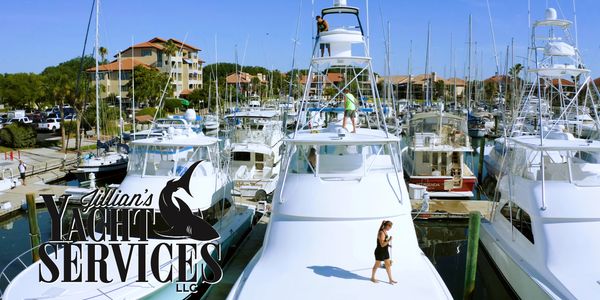 Yachts docked at a marina with people on a yacht.