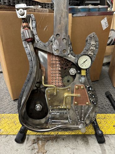 Steampunk-style electric guitar with gears and gauge.