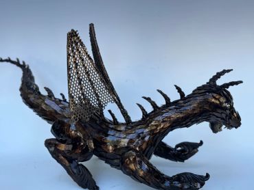 Metal dragon sculpture with detailed wings and body.