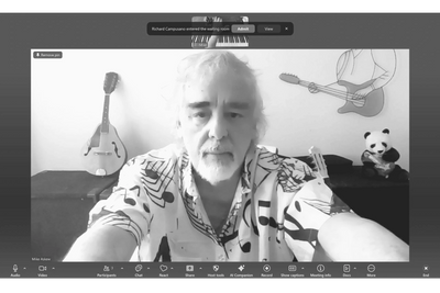 Man participating in a virtual meeting with musical decorations in the background.