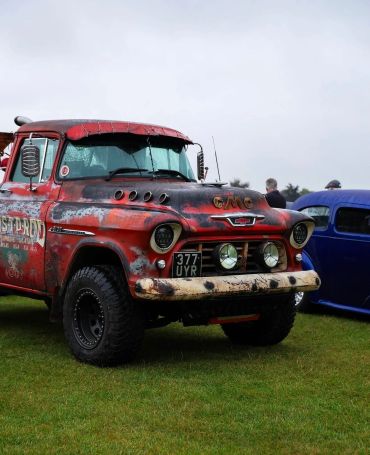 Rusty vintage GMC truck on grass.
