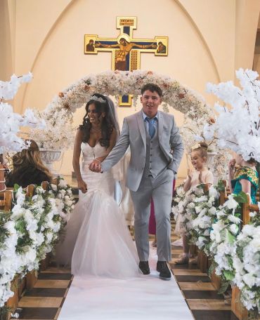 Bride and groom walking down wedding aisle.