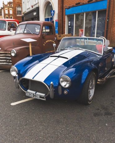 Blue vintage convertible car with white stripes.