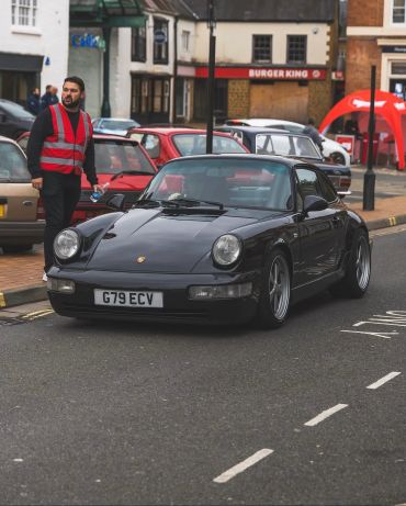 Black Porsche sports car parked on street.