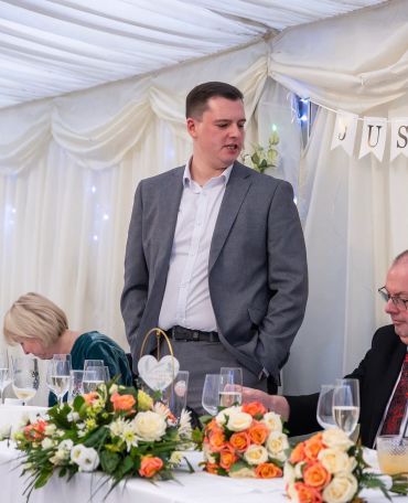 Man giving a speech at a wedding reception.