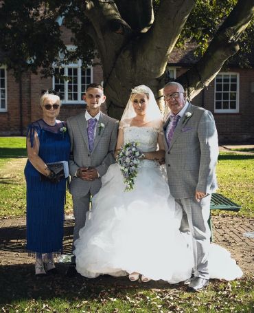 A wedding group photo under a tree.