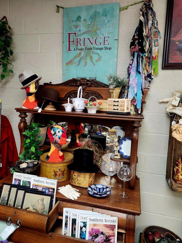 Vintage shop display with hats, gloves, and decor on wooden shelves.