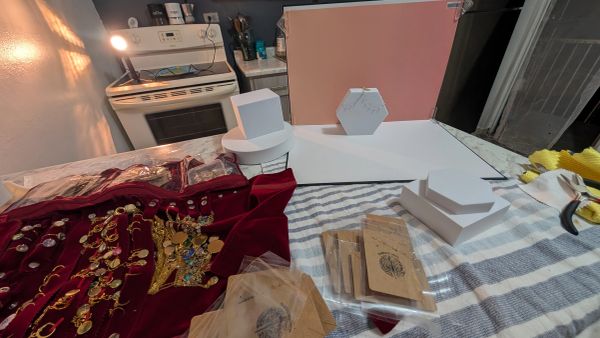 Jewelry display setup with red velvet fabric and hexagonal white boxes.