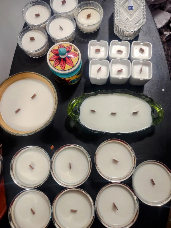 Various handmade candles in different containers.
