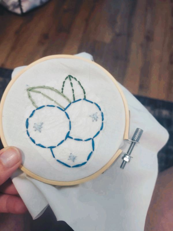 Simple embroidery of three berries with leaves.