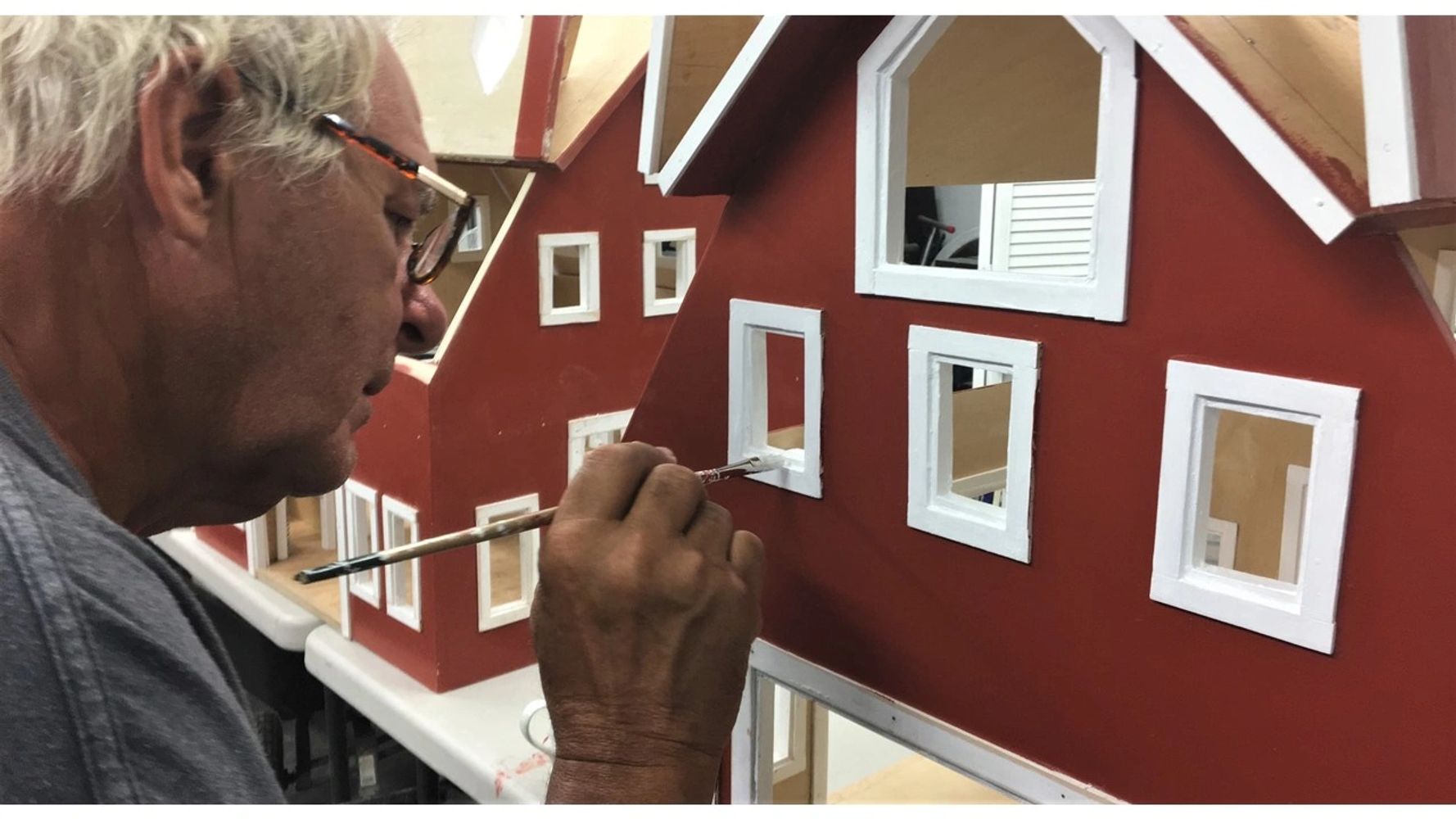 A worker in the process of making custom handmade dollhouses