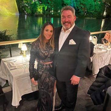 Couple posing at an elegant outdoor restaurant at night.
