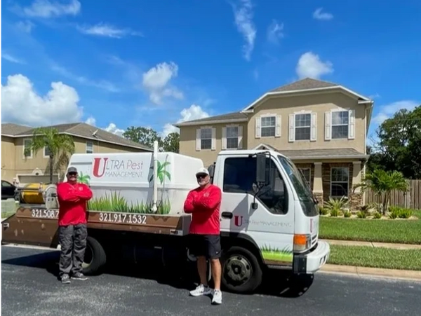 Business owners in front of pest control truck