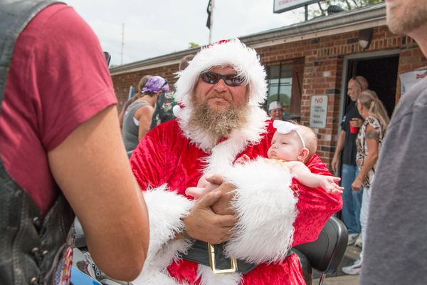 Christmas in August fundraiser. Biker Santa holding a baby. 
