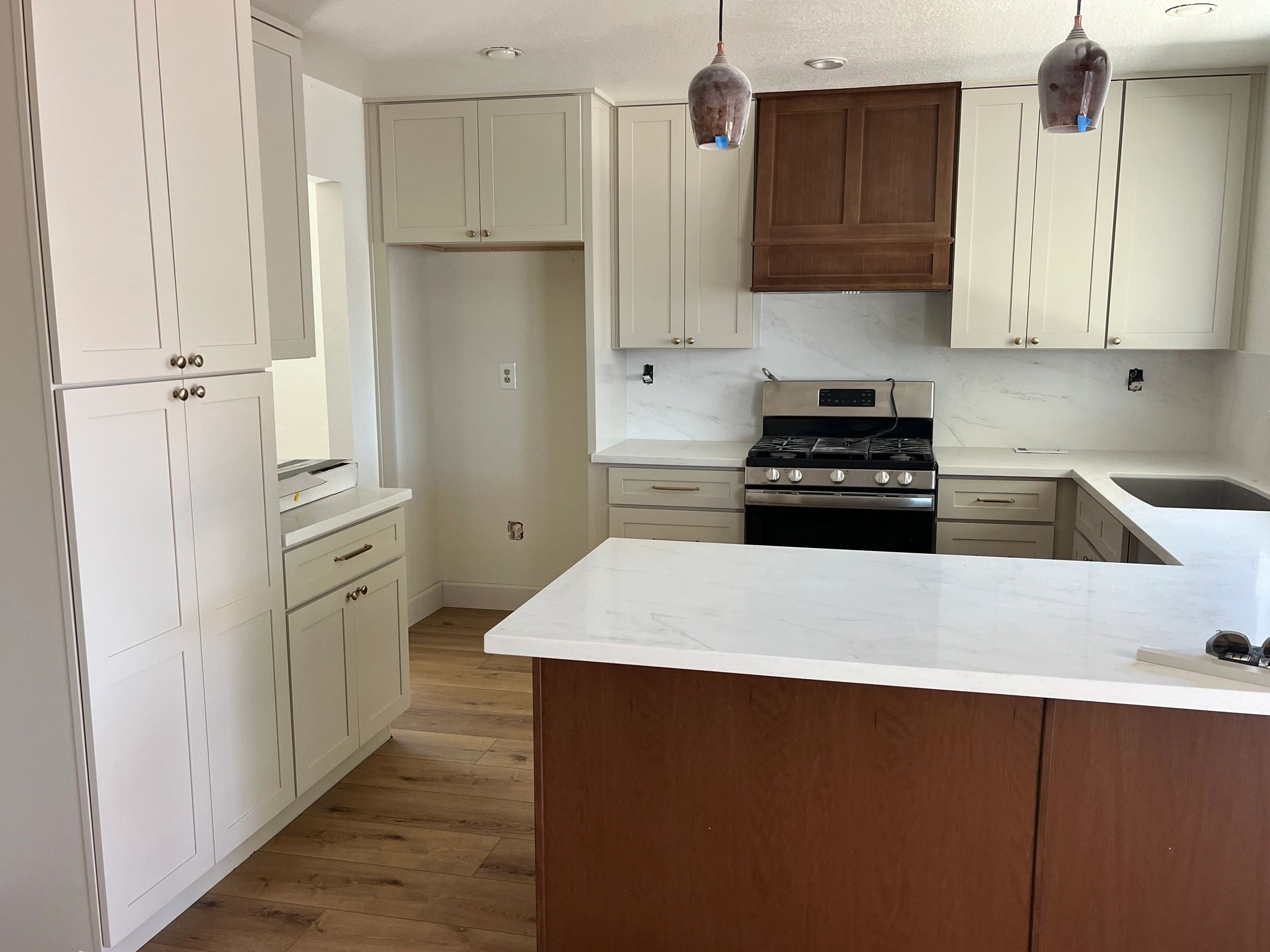 Modern kitchen with beige cabinets and quartz countertops.