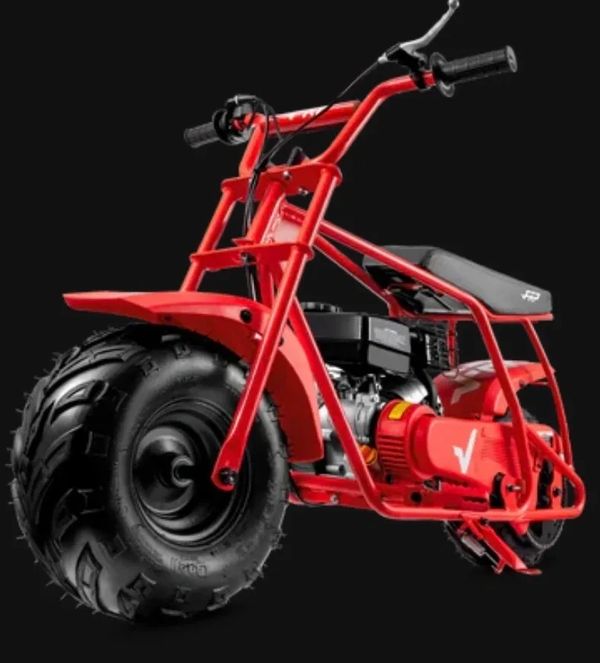 A red mini dirt bike with thick tires on a black background.