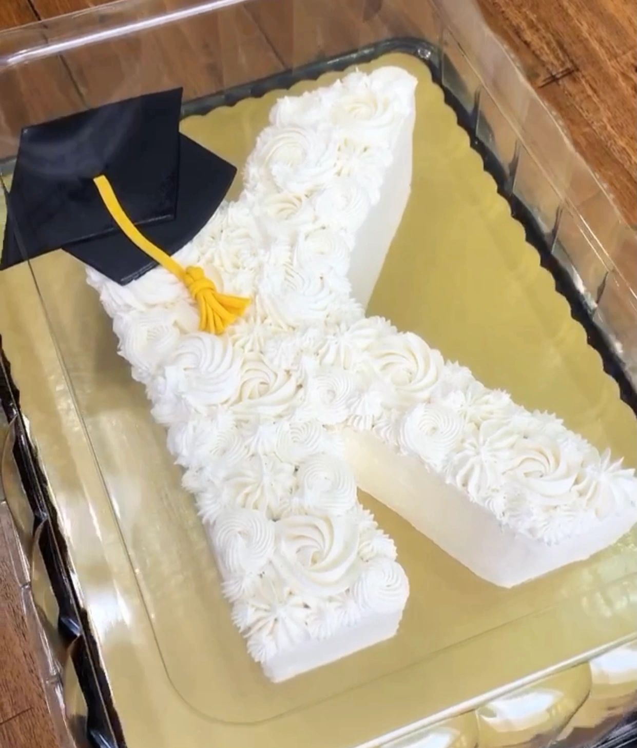 Number-shaped cake decorated with white frosting and a graduation cap.