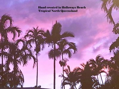 Silhouetted palm trees against a vibrant purple and pink sunset sky.