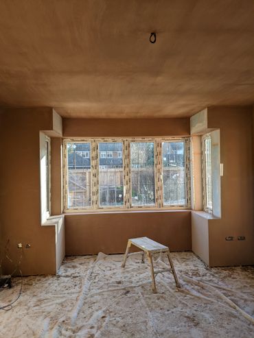 plastered geometric window bay in a large bedroom walls and ceiling are polished and shining. 