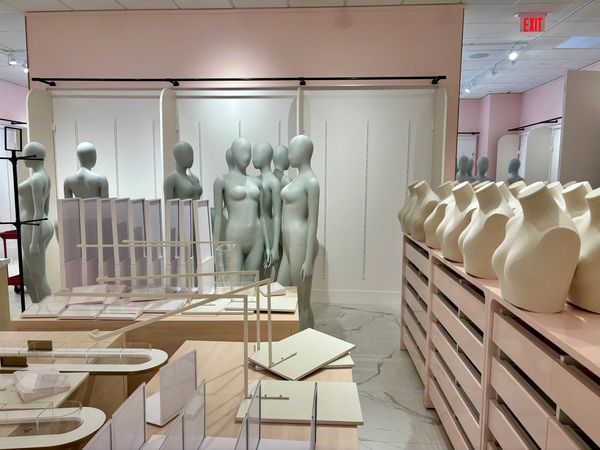 Store interior with mannequins and display fixtures arranged neatly.