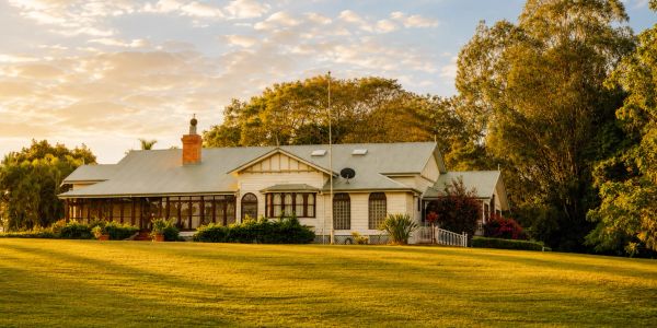 A house surrounded by trees during sunset.