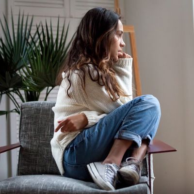 Woman sitting in chair biting nails.  Seeking anxiety therapy.