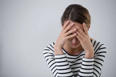 Woman putting head in hands.  Seeking OCD treatment.