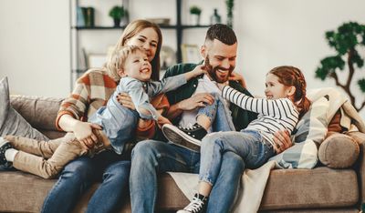 Family of four smiling.  Seeking family therapy.