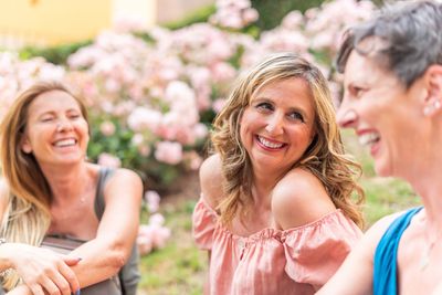 Three women smiling.  Seeking adult therapy.