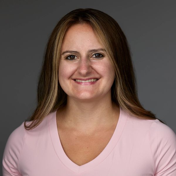 Female therapist in pink shirt smiling.  Eating disorder therapy, anxiety therapy, OCD treatment 