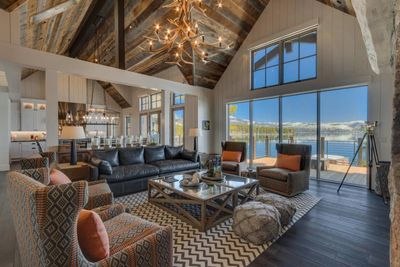 Cozy living room with rustic beams and lake view windows.