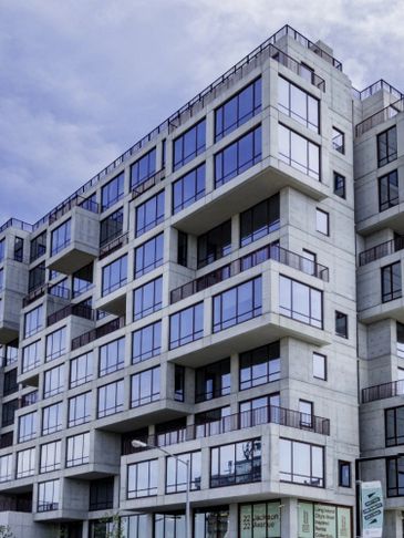 Modern apartment building with large glass windows and balconies.