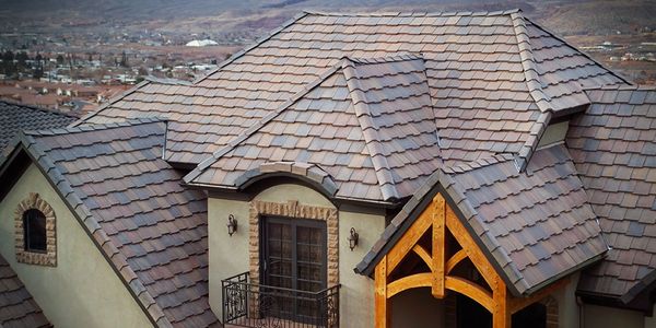 Detailed roof with shingles and wooden beams on a house.