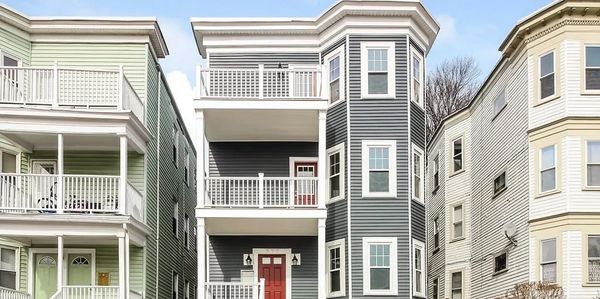 Three multi-story residential buildings with porches in a row.