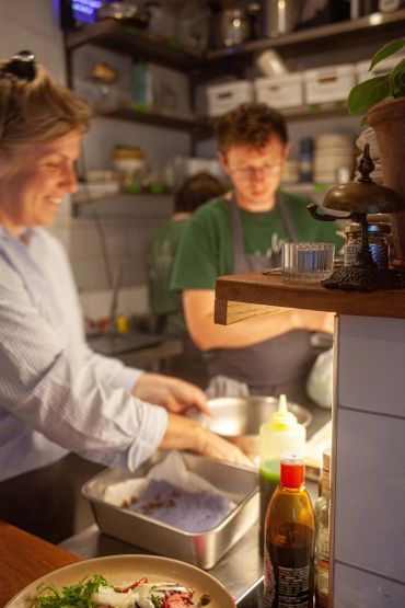 Two people preparing food in a kitchen.