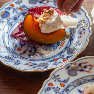 A slice of orange pumpkin dessert with whipped cream and nuts.