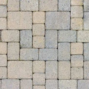 Patterned stone pavement with interlocking rectangular and square tiles.