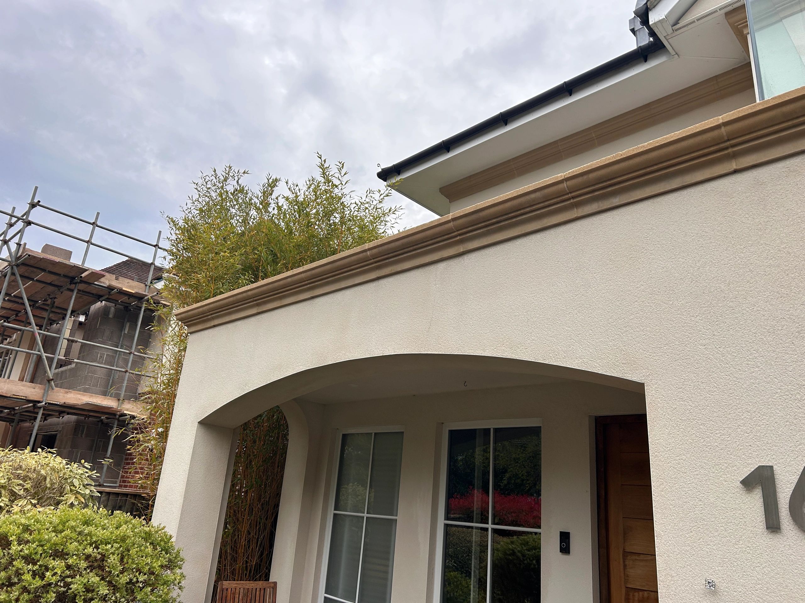 Section of render cleaned using softwashing, revealing a fresh and revitalised surface.
